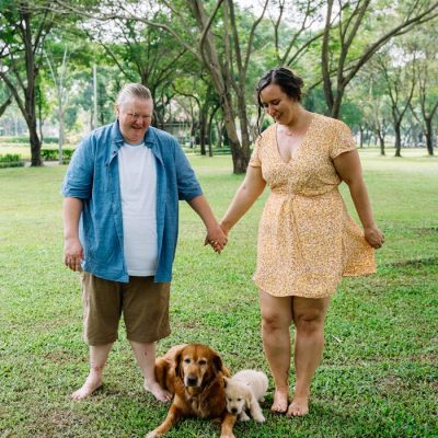 A couple enjoying a day in the park with their golden retrievers, showcasing love and companionship.